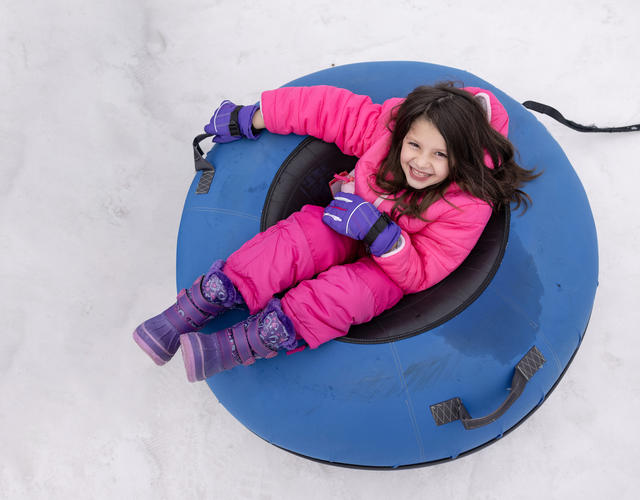 Wish kid Rivkah in an inner tube in the snow