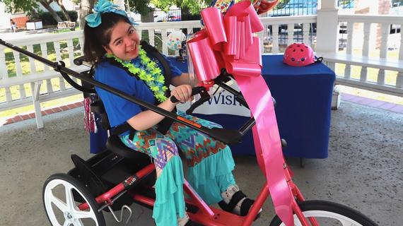 Sara riding her new adaptive bicycle