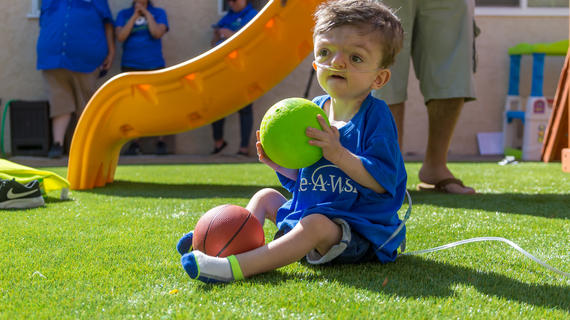 Vicente holding ball in his new backyard.