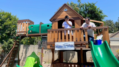 Ej stands on his play structure with water balloons