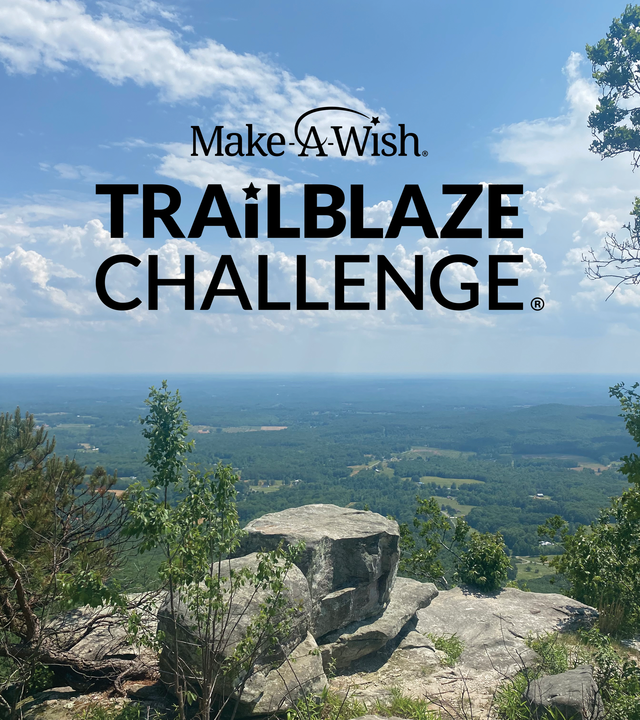 View overlooking Pilot Mountain. Bright blue sky with green trees below and large rock faces